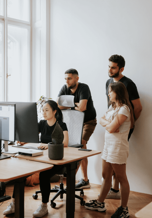 Team members working on a project behind a computer